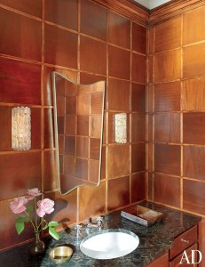 ONLINE EXCLUSIVE - POWDER ROOM Swedish sconces from the 1970s sparkle against the powder room’s paneled walls; the ’40s mirror is attributed to Gio Ponti.
